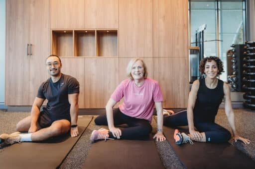 A personal trainer guiding a client through a full-body stretching routine at Focus Health & Fitness Norwest, improving flexibility, posture, and mobility.