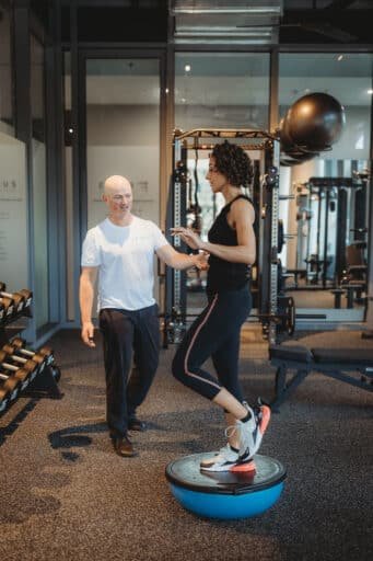 Personal Trainer supporting client during balance and stability training on BOSU ball at Focus Health & Fitness in Norwest NSW