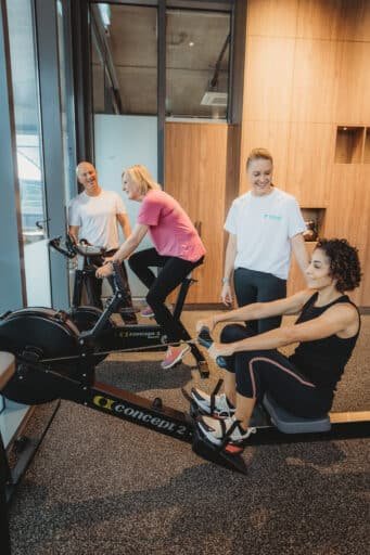 Personal trainers coaching clients on rowing machine and bike at Focus Health & Fitness Norwest, near Bella Vista, Castle Hill, Kellyville, and the Hills District.