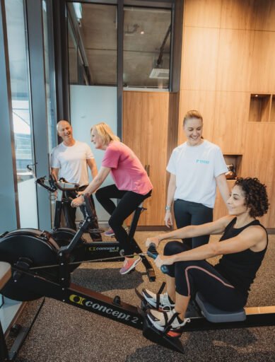 Personal trainers coaching clients on rowing machine and bike at Focus Health & Fitness Norwest, near Bella Vista, Castle Hill, Kellyville, and the Hills District.